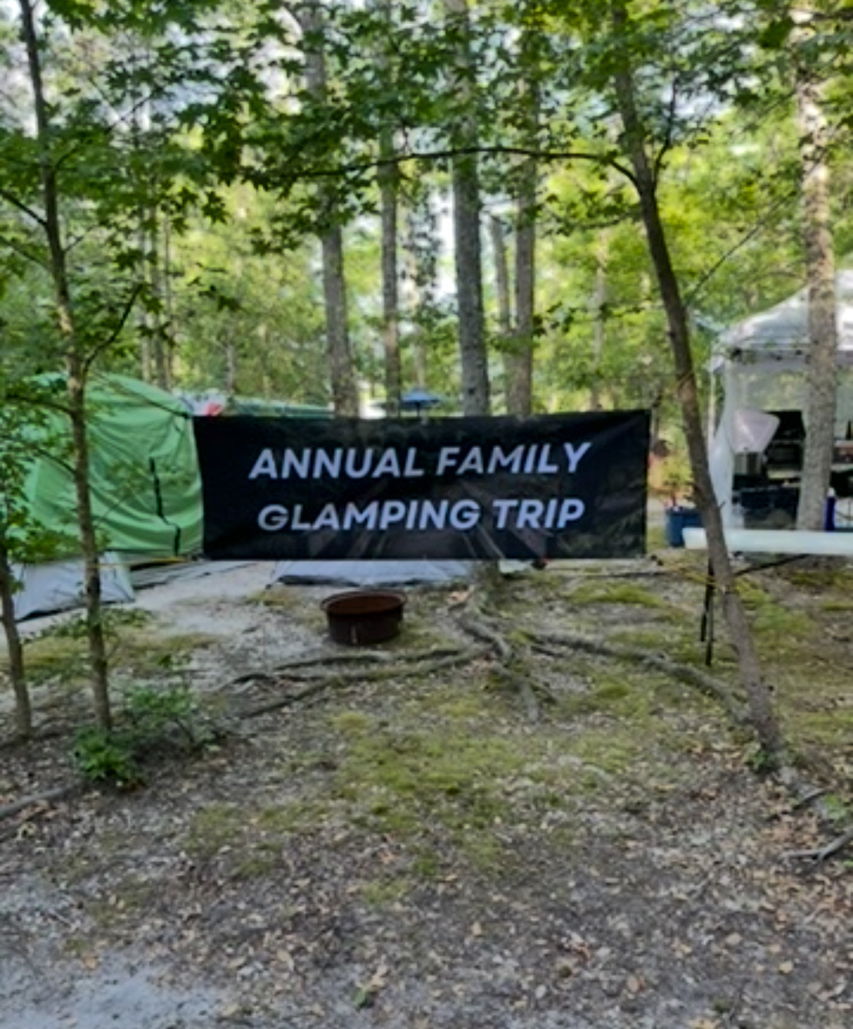 Annual Family Glamping Trip banner hanging between trees