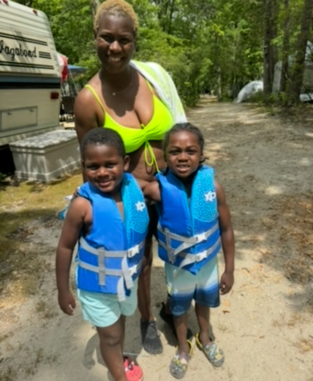 Woman and two children in life vests at the glamping site